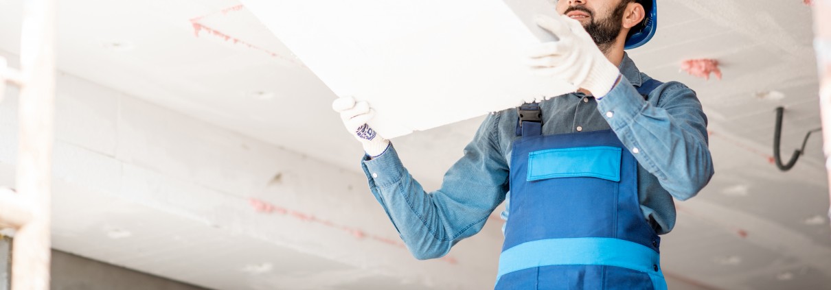 Lavoratore edile lavora a isolamento acustico di un soffitto