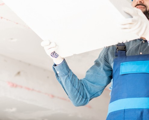 Lavoratore edile lavora a isolamento acustico di un soffitto