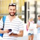 A picture of a young student standing and smiling in the campus